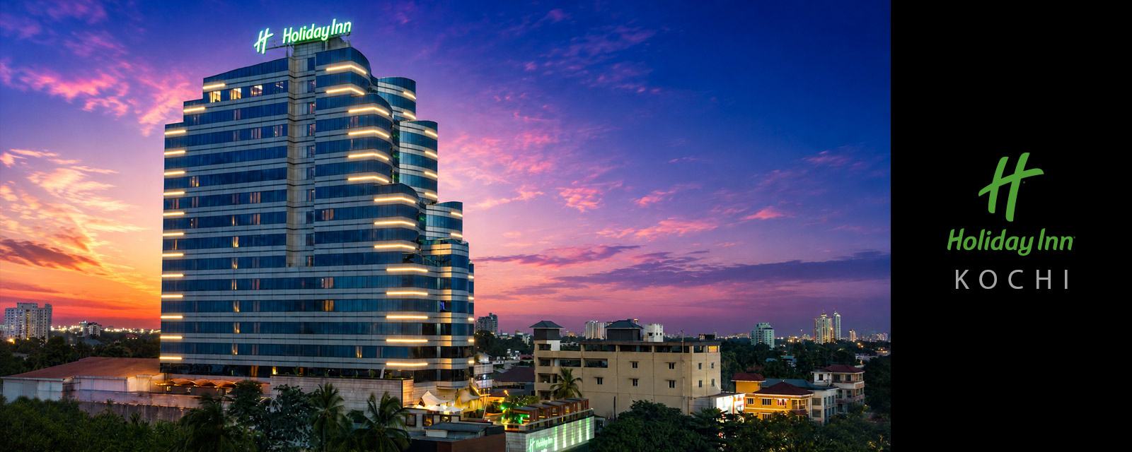 Holiday Inn Kochi lit up at dusk.